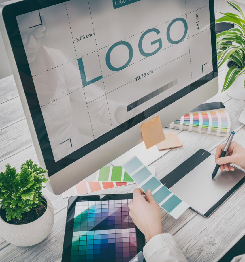 Designer working on a logo update for a brand refresh, using colour swatches and digital tools
